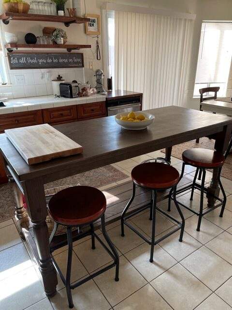Concord kitchen island with reverse-side seating and dark wood top in customer kitchen