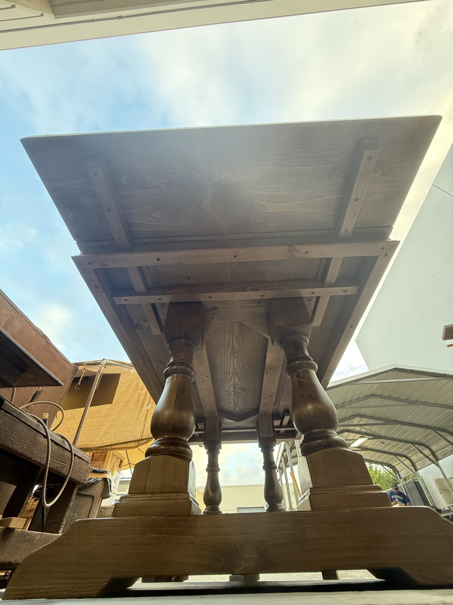 Wooden extension support arms extending through the table apron beneath the tabletop